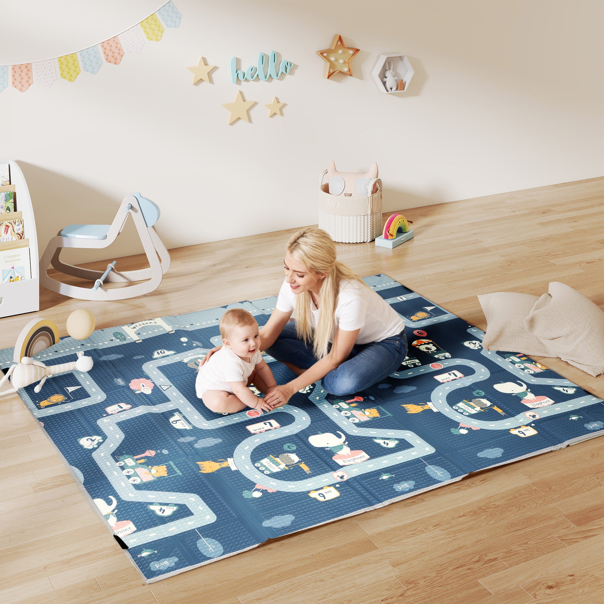 Woman and child playing on a large blue play mat with road designs in a room.