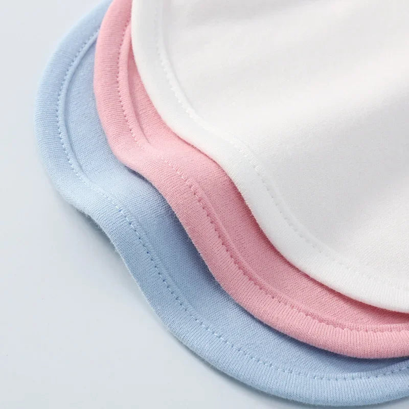 Three baby bibs in white, pink, and blue on a light gray background