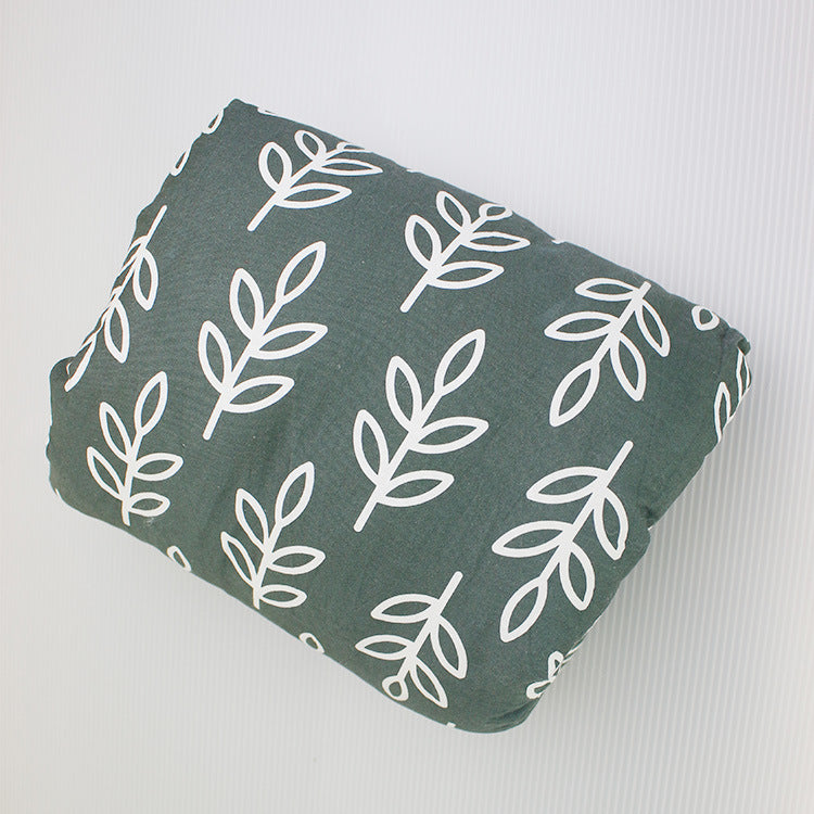 Arm pillow with white leaf pattern on green with a white background